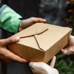livreur remettant un colis sur le pas de la porte