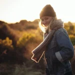 Femme nouant une écharpe en laine autour du cou