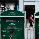 Particulier portant un grand carton à expédier